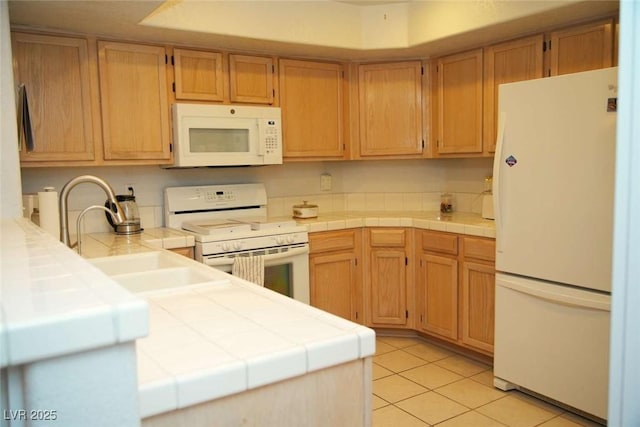 kitchen featuring white appliances, tile countertops, sink, and light tile patterned floors