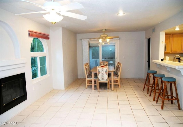 dining area with sink, ceiling fan, and light tile patterned flooring