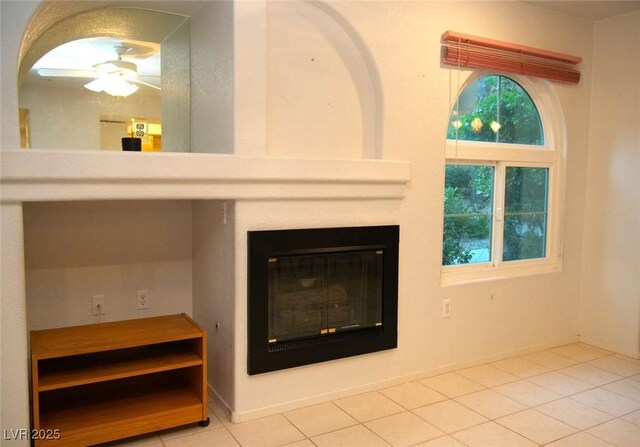 room details with baseboards, a large fireplace, and ceiling fan