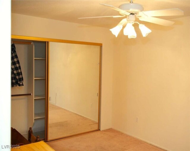 unfurnished bedroom featuring a closet, carpet floors, and ceiling fan