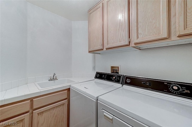 clothes washing area with cabinets, separate washer and dryer, and sink