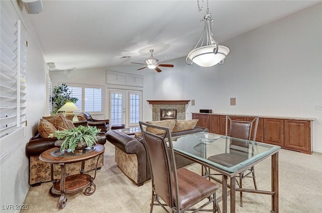 dining space with vaulted ceiling, light colored carpet, french doors, and ceiling fan