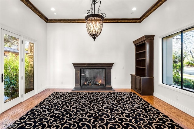 living room featuring ornamental molding, a healthy amount of sunlight, and light wood-type flooring