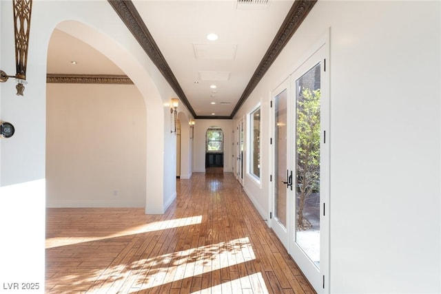 hallway with ornamental molding and wood-type flooring