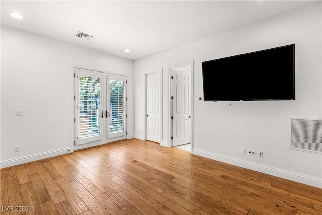 unfurnished living room with french doors and light wood-type flooring