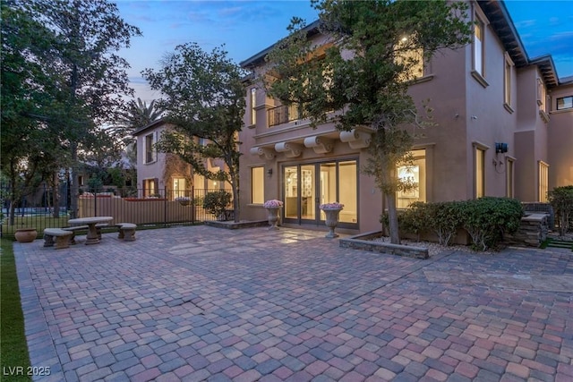 back house at dusk with a patio area