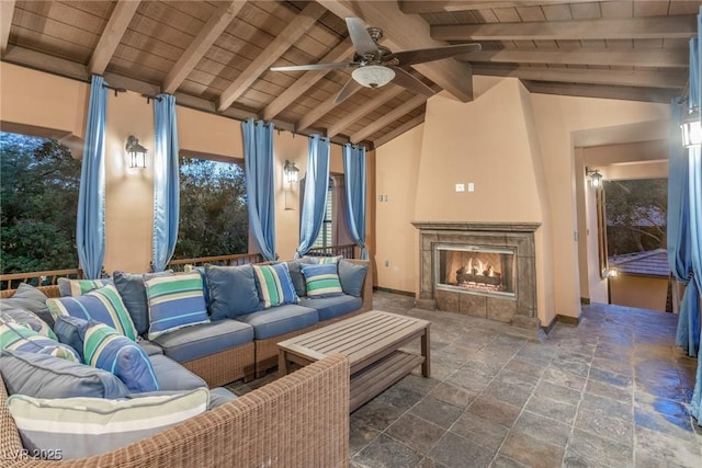 living room featuring ceiling fan, lofted ceiling with beams, a tile fireplace, and wooden ceiling