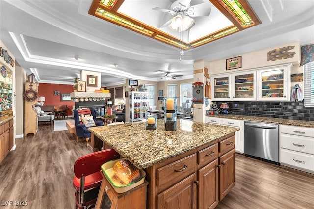 kitchen featuring white cabinetry, a raised ceiling, dishwasher, and a kitchen island