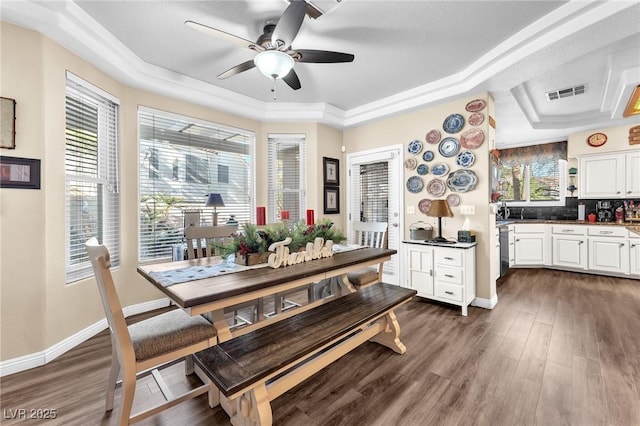 dining room featuring ceiling fan, dark hardwood / wood-style floors, and a raised ceiling