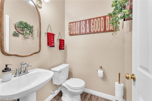 bathroom featuring wood-type flooring, sink, and toilet