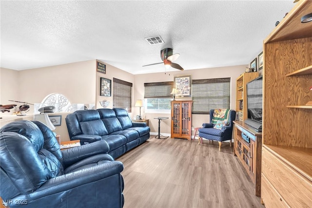 living room featuring hardwood / wood-style floors, a textured ceiling, and ceiling fan