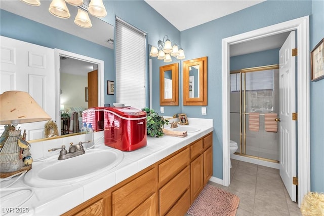 bathroom with vanity, tile patterned flooring, a shower with shower door, and toilet