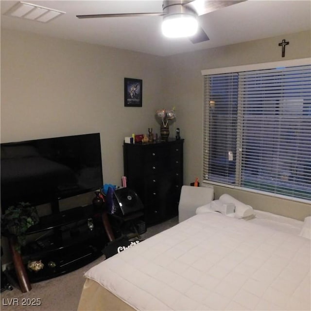 carpeted bedroom featuring visible vents and a ceiling fan