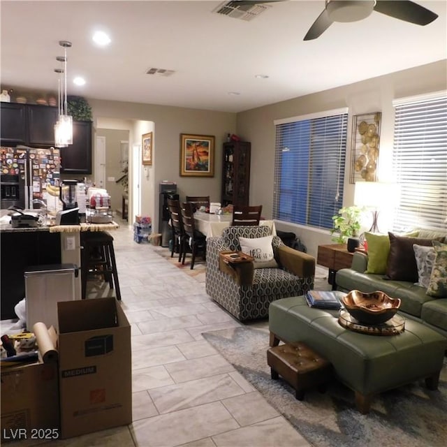 living room with ceiling fan, visible vents, and recessed lighting