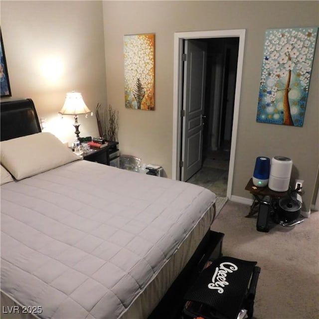 bedroom featuring ensuite bath, baseboards, and light colored carpet