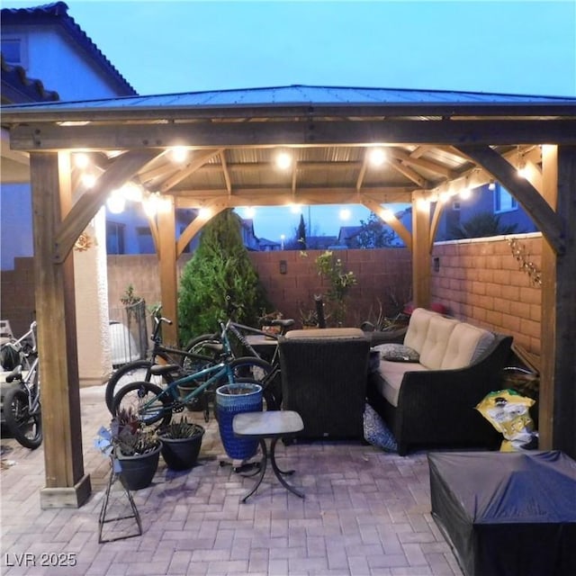 patio terrace at dusk with a fenced backyard and a gazebo