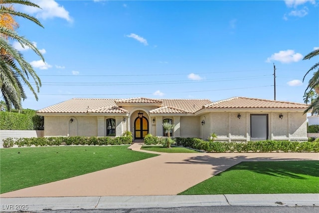 mediterranean / spanish-style home with a front lawn