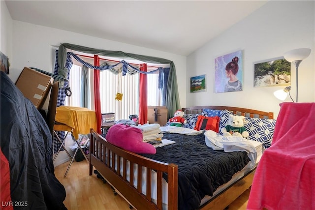 bedroom featuring lofted ceiling and hardwood / wood-style flooring