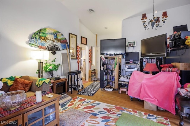 rec room featuring high vaulted ceiling, a chandelier, and light wood-type flooring