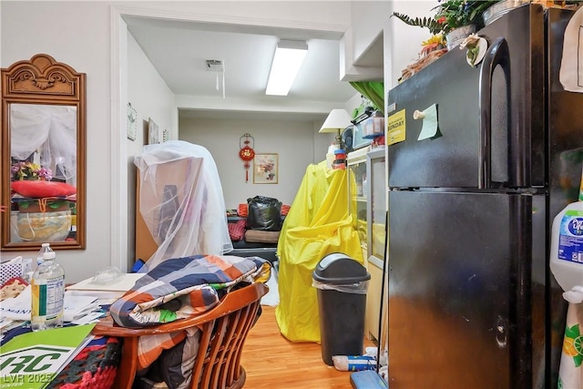 kitchen with black refrigerator and hardwood / wood-style flooring