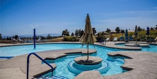 view of swimming pool with a jacuzzi and a patio area