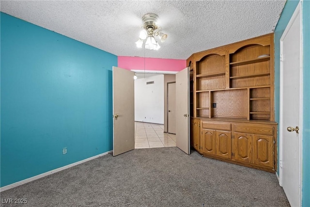 unfurnished bedroom featuring light colored carpet and a textured ceiling