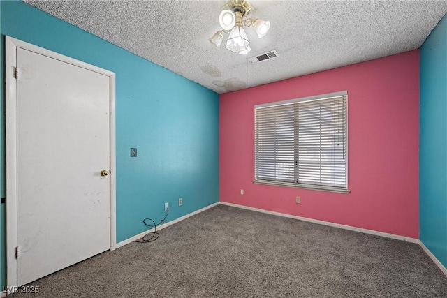 carpeted empty room featuring a textured ceiling