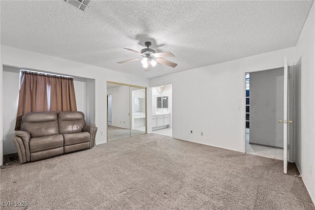 unfurnished living room featuring ceiling fan, light carpet, and a textured ceiling