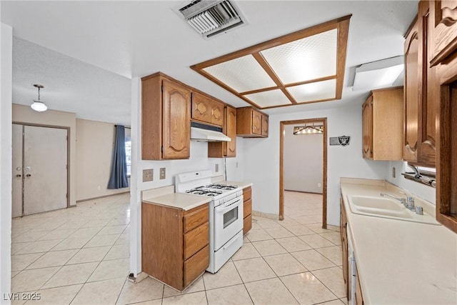 kitchen with white gas range, light tile patterned floors, and sink