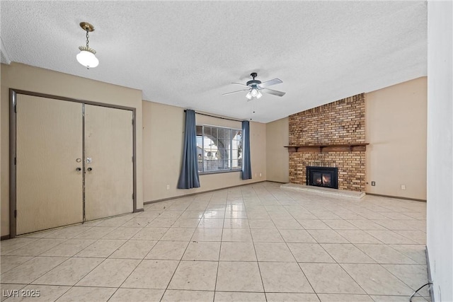 unfurnished living room featuring light tile patterned flooring, a brick fireplace, a textured ceiling, and ceiling fan