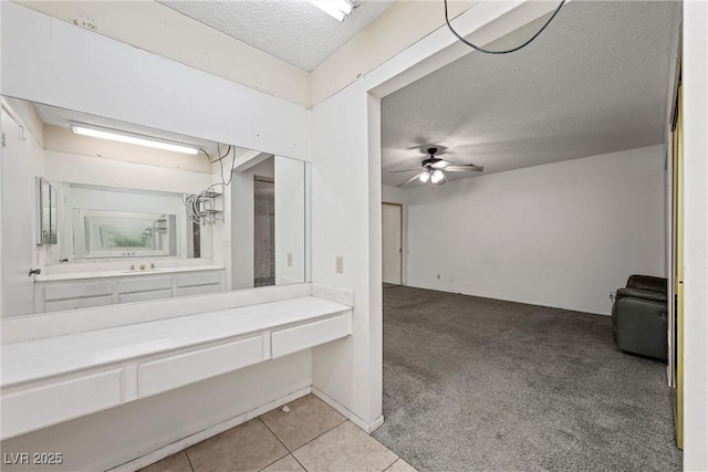 bathroom featuring ceiling fan, tile patterned floors, and a textured ceiling