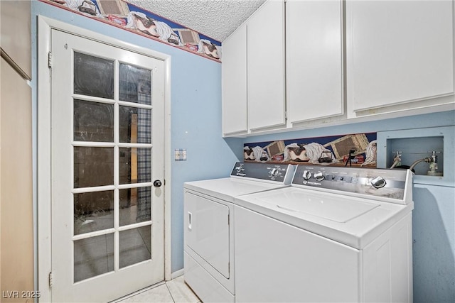 clothes washing area with cabinets, light tile patterned flooring, washer and dryer, and a textured ceiling