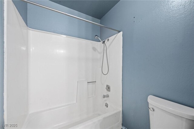 bathroom featuring shower / tub combination and toilet