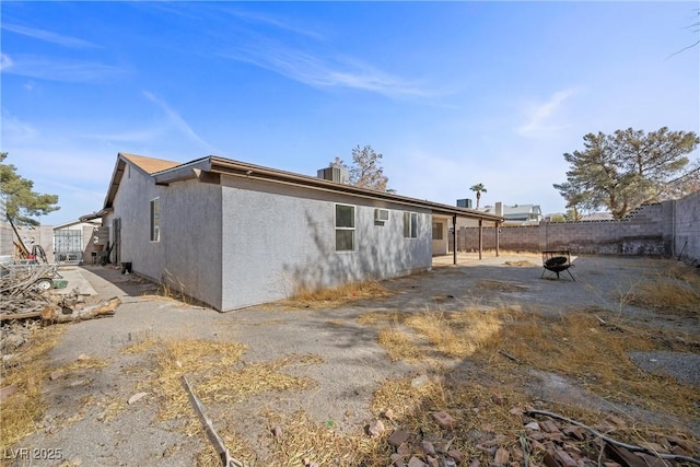 back of property featuring a fire pit and a patio area