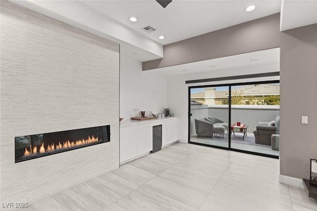 bar featuring a fireplace and white cabinets