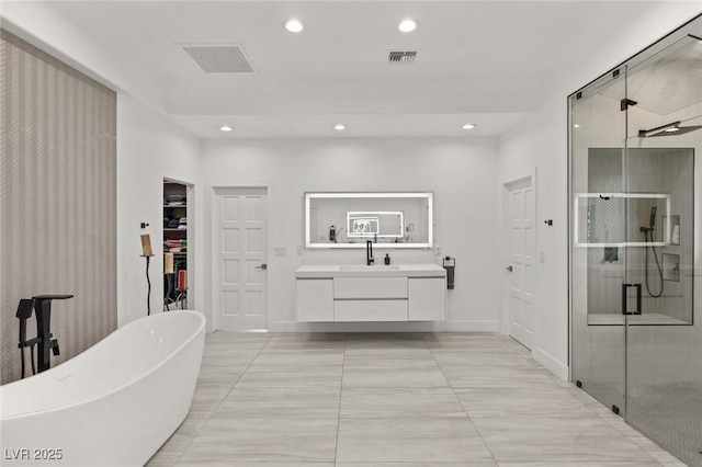 bathroom featuring vanity and independent shower and bath