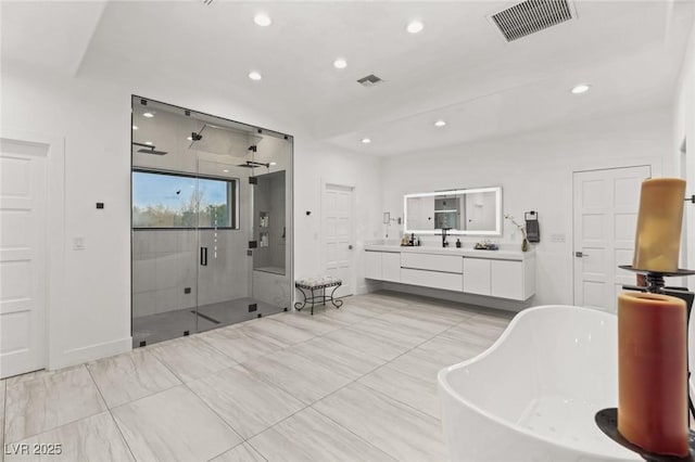 bathroom with vanity and shower with separate bathtub