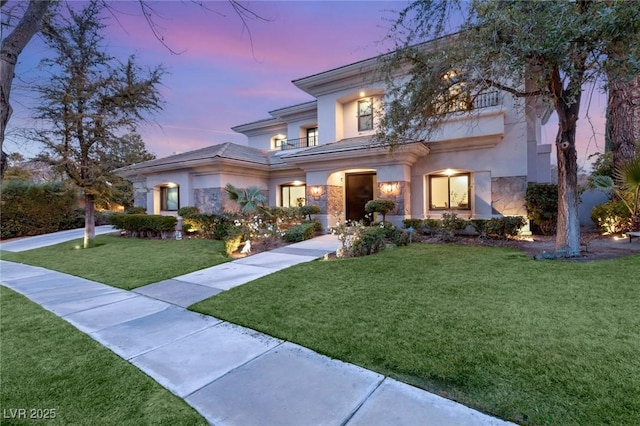 view of front of house with a yard and a balcony