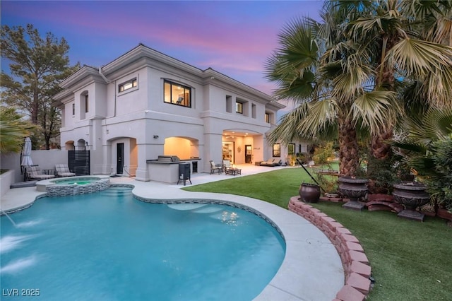 back house at dusk featuring a pool with hot tub, a patio area, and a lawn