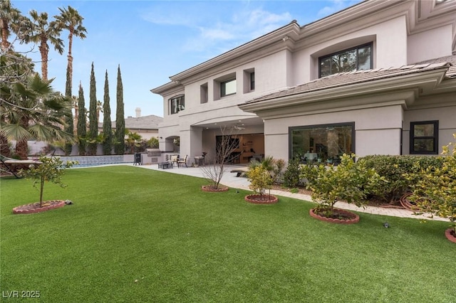 back of house with a lawn and a patio