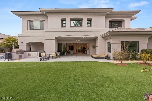 back of property featuring a yard, a patio, and exterior kitchen