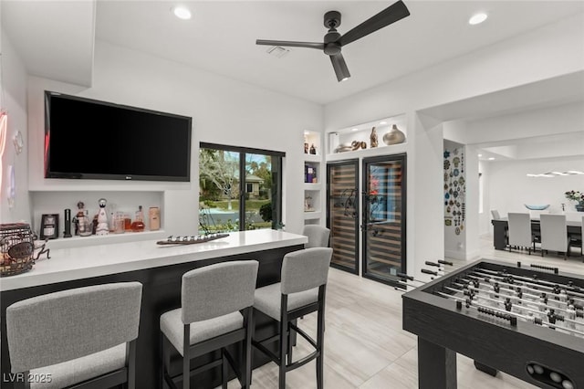 bar featuring built in features and ceiling fan