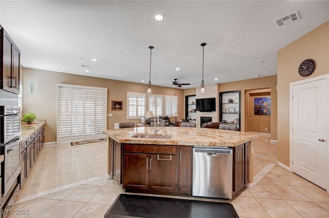 kitchen with sink, hanging light fixtures, an island with sink, light tile patterned flooring, and stainless steel dishwasher