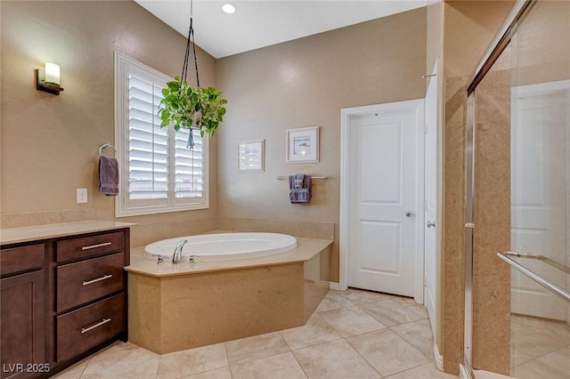 bathroom featuring vanity, a bath, and tile patterned floors