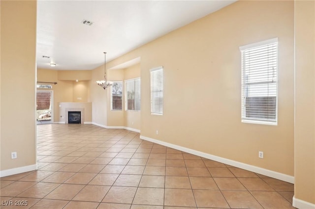 unfurnished living room with light tile patterned flooring and a chandelier