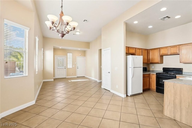 kitchen featuring light tile patterned floors, decorative light fixtures, gas stove, and white refrigerator