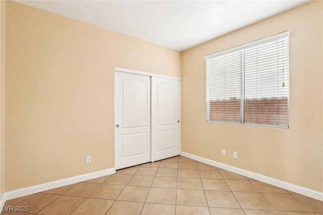 unfurnished bedroom featuring a closet and light tile patterned floors