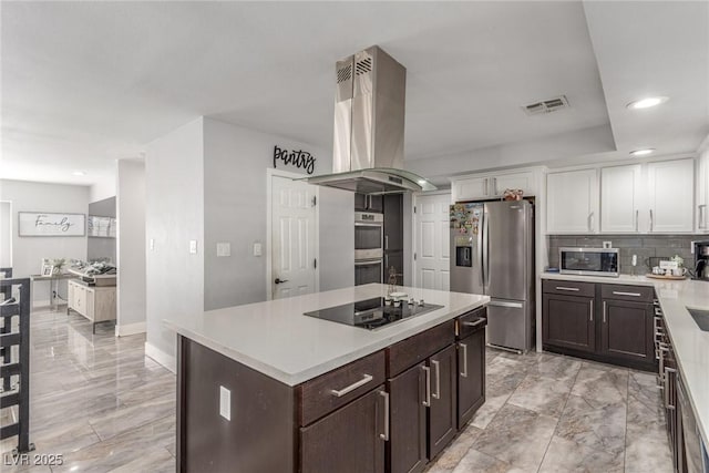 4410 E Boston Ave, Las Vegas, NV 89104 - kitchen with appliances with stainless steel finishes, white cabinetry, backsplash, island exhaust hood, and a center island