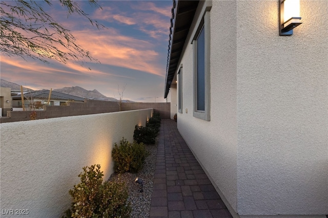 property exterior at dusk featuring a patio and a mountain view