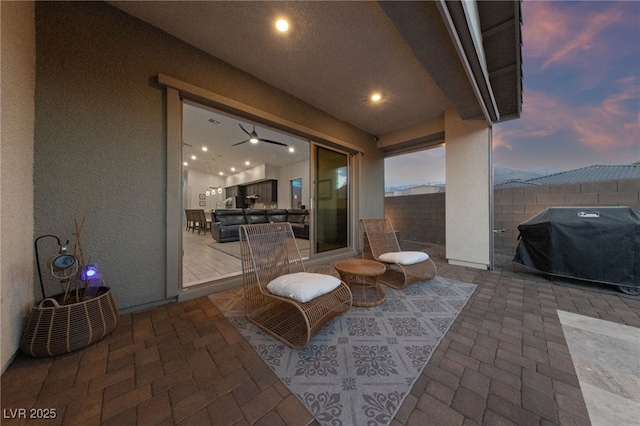 patio terrace at dusk featuring a grill